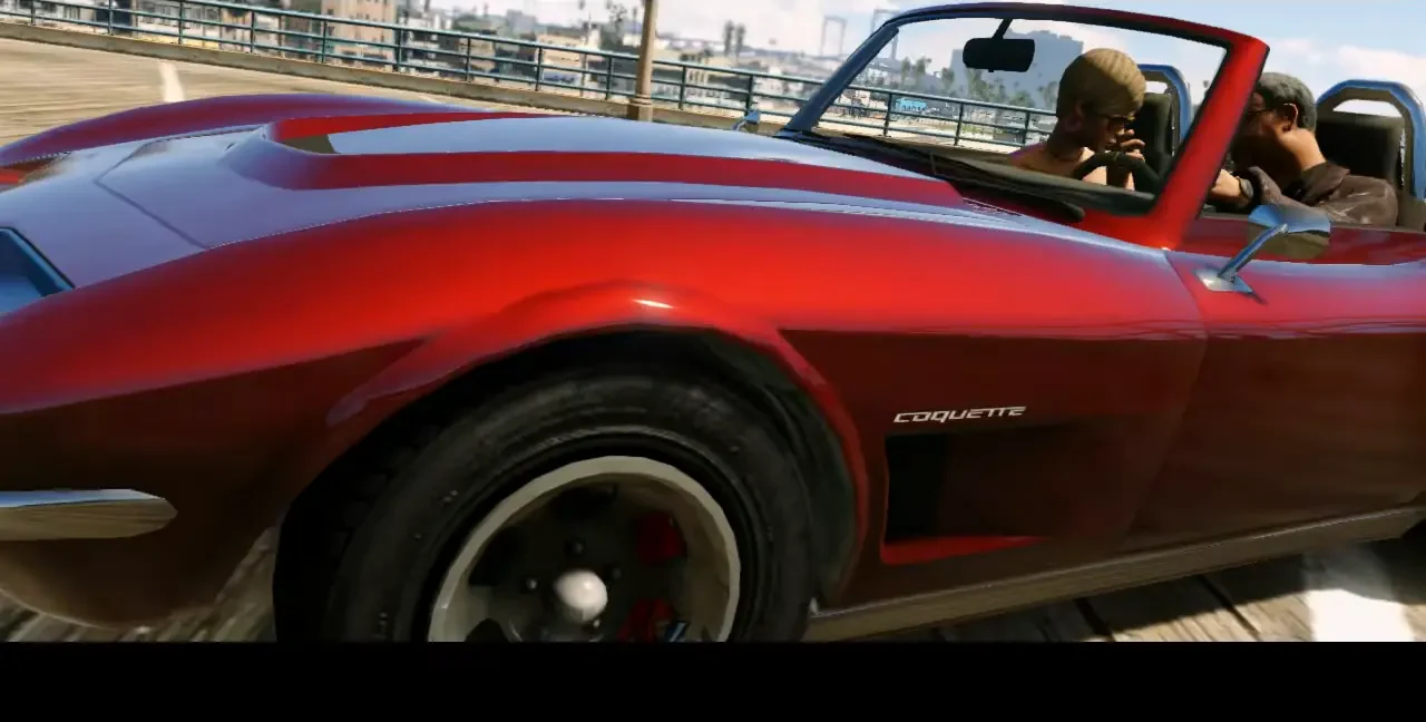 Red Invetero Coquette Classic convertible driving across a bridge, close on the front fender badge
