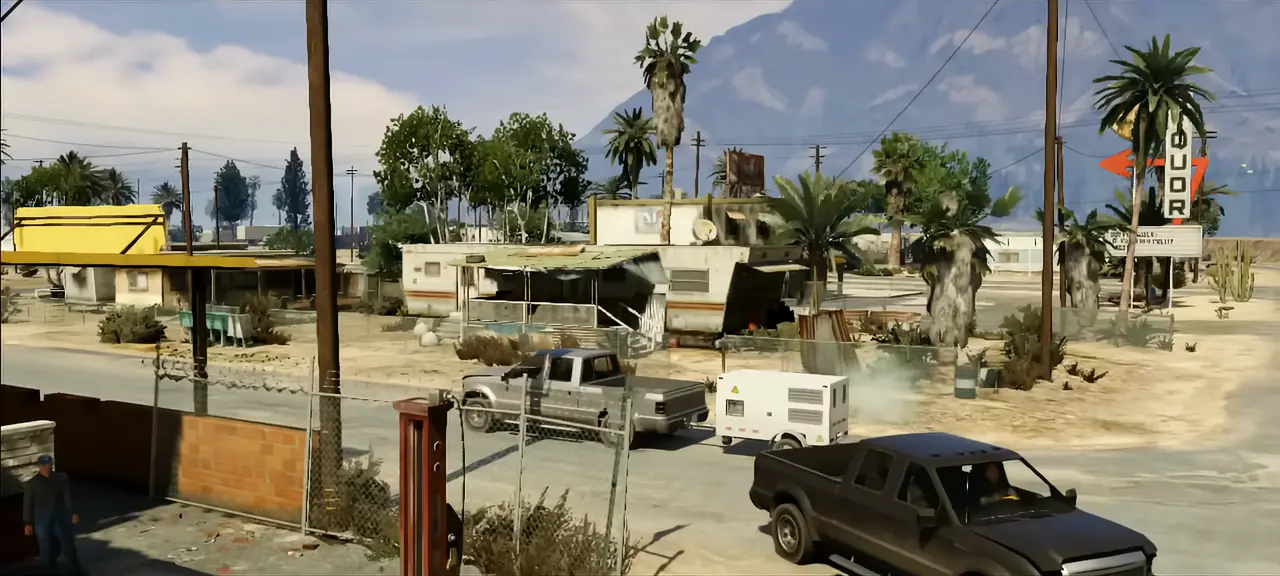 Trailers, pickups and a liquor-store sign in Sandy Shores beneath the mountains