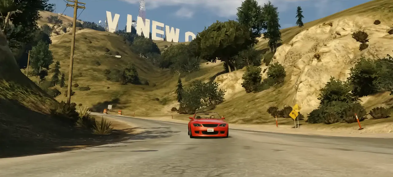 A red convertible driving a winding hill road below the Vinewood sign