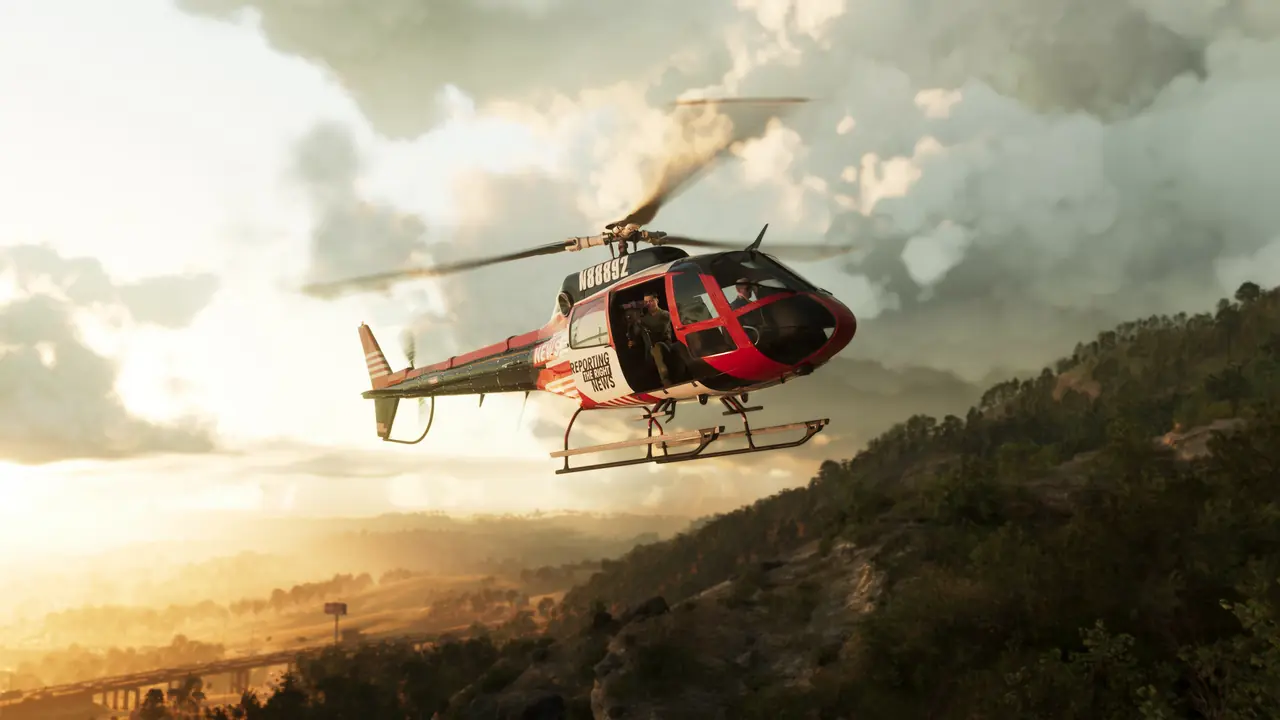 A red-and-white helicopter flying low over forested hills at sunset
