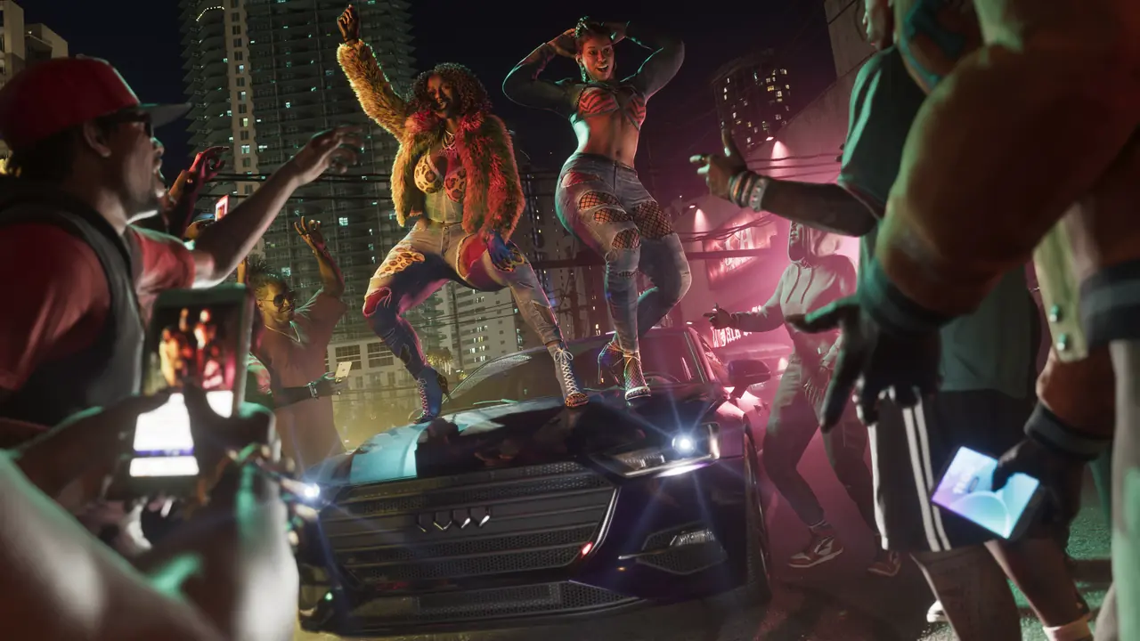The Real Dimez dancing on the hood of a car at a night-time street party while a crowd films them